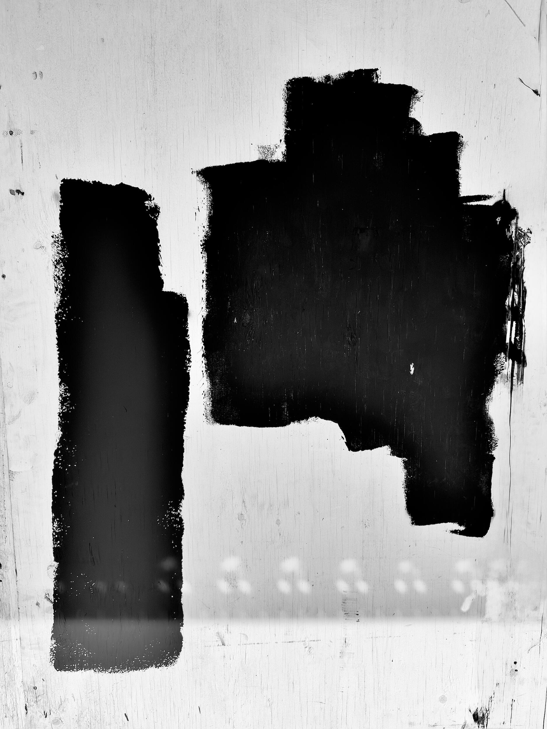 double - glyph | LA - Two parallel black shapes interacting on a textured wood surface. Industrial noir black-and-white photography, Los Angeles, California. 1/1 archival pigment print by Barton Caplan